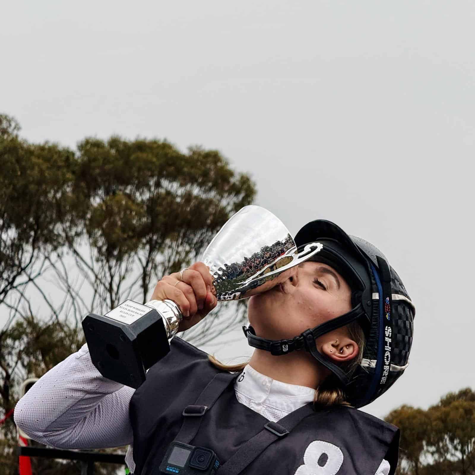 Female rider drinking from trophy at Kulin Bush Races 2025 event.